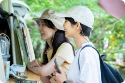 キッチンカーの商品を選ぶ2人の女性