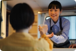 キッチンカーから商品を手渡す店員