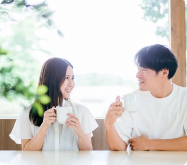 カップを手に取り笑顔で見つめあう男女